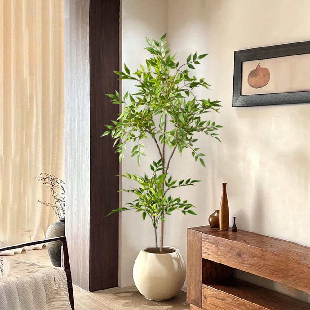 A tall artificial Nandina plant with green leaves in a beige pot displayed on a wooden shelf.