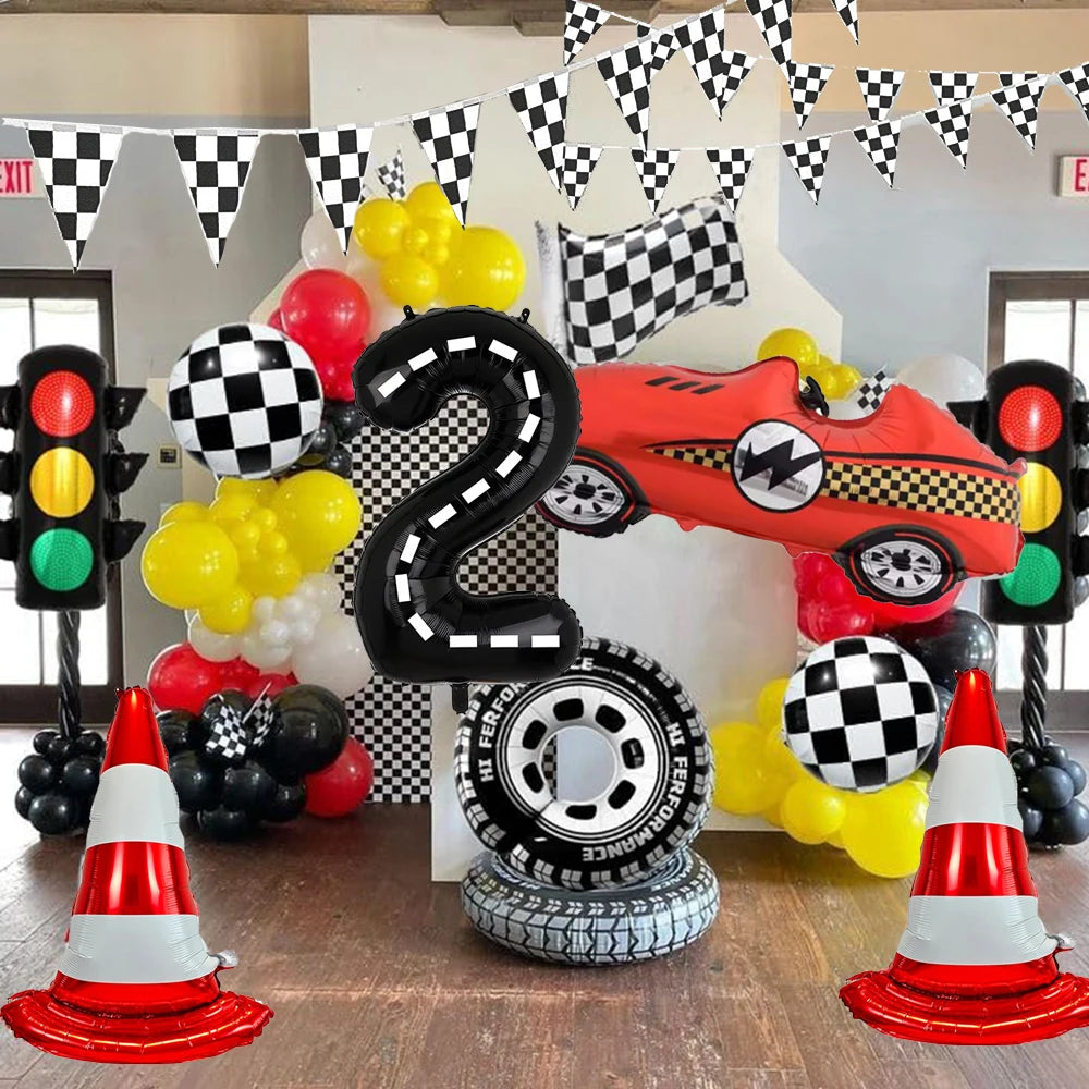 A display featuring a black number 2 balloon, various colored balloons, and a red race car model surrounded by traffic light 