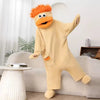A fluffy, orange monster coral fleece hooded sleepsuit standing upright in a bright living room setting.