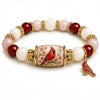 A stretch charm bracelet featuring round beads of pink, white, and deep red stones with a decorative gold clasp and a small b