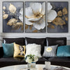 A set of three modern abstract floral wall art prints featuring white and gold leaves on a dark gray background.