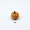 A small, round velvet pumpkin decoration with a dark stem, shown against a white background.
