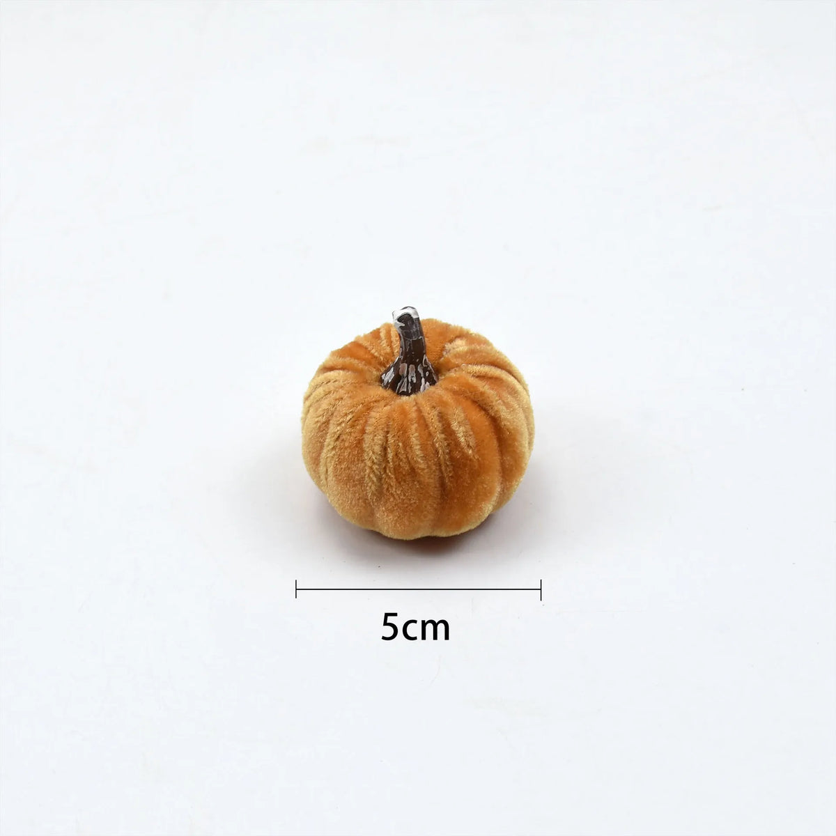 A small, round velvet pumpkin decoration with a dark stem, shown against a white background.