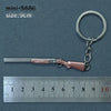 A miniature alloy gun model keychain with a pink finish is shown next to a ruler.