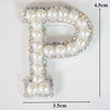 A rhinestone patch shaped like the letter P, featuring white and iridescent stones.