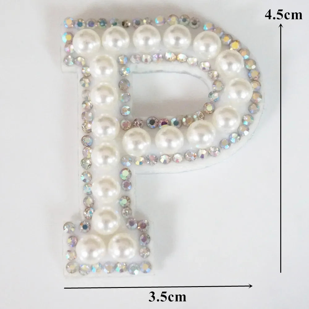 A rhinestone patch shaped like the letter P, featuring white and iridescent stones.