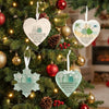Handcrafted acrylic snowflake ornaments hanging on a Christmas tree with red and gold baubles