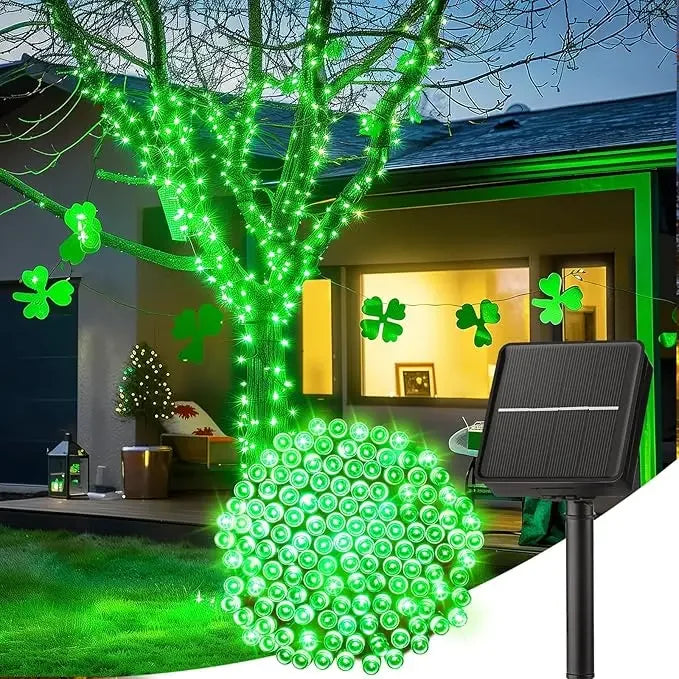 A string of bright green LED lights is displayed on a tree and ground, illuminating an outdoor garden area.