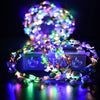 A glowing flower wreath headband with multiple colored LEDs resting on a reflective surface.
