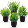 A set of four small artificial bonsai plants in various shades of green potted in black containers.