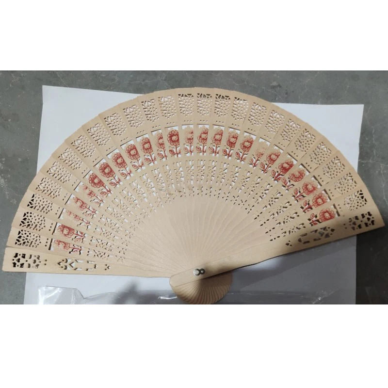 Hand carved bamboo folding fan with intricate cutout patterns and red floral accents