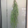 Artificial hanging ivy vine displayed against a vertical measuring scale.