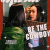 A poster featuring two women with dark hair and dramatic makeup, set against a red background with the text BE THE COWBOY.