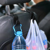A close-up of car headrest hooks used for hanging bags and bottles on a black leather seat.