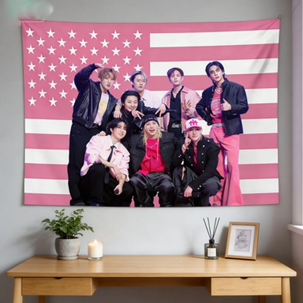 A pink American flag tapestry featuring seven Kpop idols standing in front of the flag.