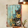 A vintage metal tin sign featuring multiple cats in various expressions against a distressed teal background.