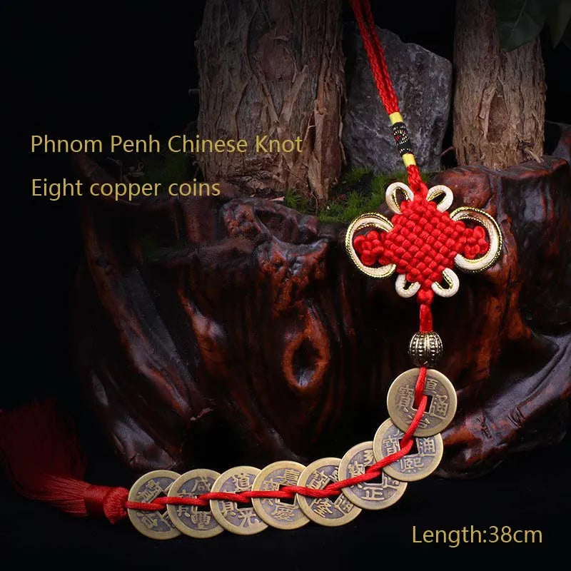 A pendant featuring eight copper coins tied in a Chinese knot, displayed against a dark, rustic background.