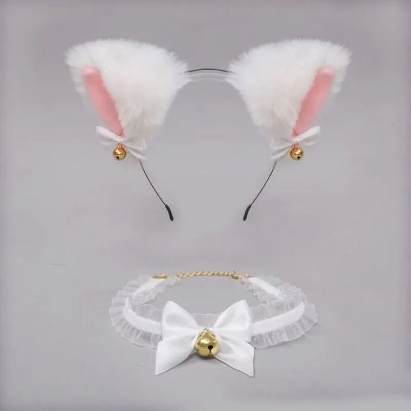 A pair of white faux cat ear headband with pink inner lining and gold bell accents, shown above a white lace bow choker.