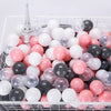 A white basket filled with a 50-pack of colorful, translucent, and opaque star-shaped balls in pink, white, and gray tones.