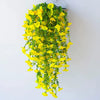 A cascading arrangement of bright yellow artificial morning glory vines hanging from a clear glass container.