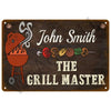 A dark metal sign with white text that reads John Smith The Grill Master and features stylized grilling tools.