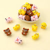 A bowl filled with various yellow and pink silicone plant beads for jewelry making and DIY crafts.