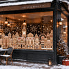 A display of Christmas gingerbread house window clings featuring detailed architectural scenes and festive lighting.