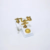 A vintage rotary desk phone miniature decor featuring brass-colored receiver and base on a white stand.