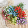 A vibrant bouquet of artificial baby's breath flowers in various colors including pink, blue, red, and purple arranged on a w