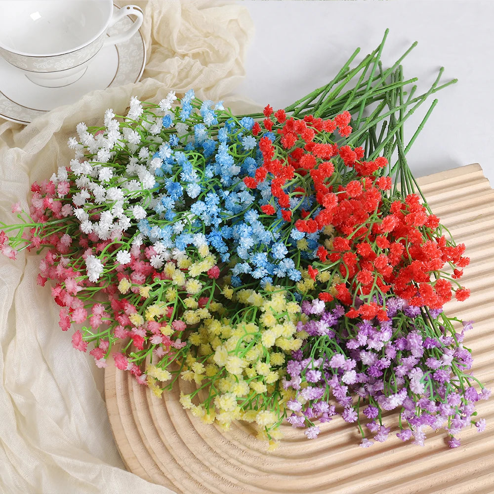 A vibrant bouquet of artificial baby's breath flowers in various colors including pink, blue, red, and purple arranged on a w