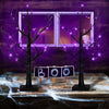 A glowing Halloween birch tree lamp with LED lights stands on a wooden table in front of a purple window.