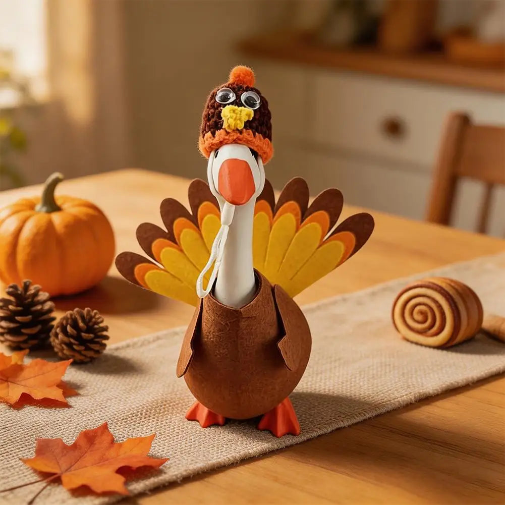 A felt turkey costume shaped like a goose statue with orange and brown feathers on a wooden table.