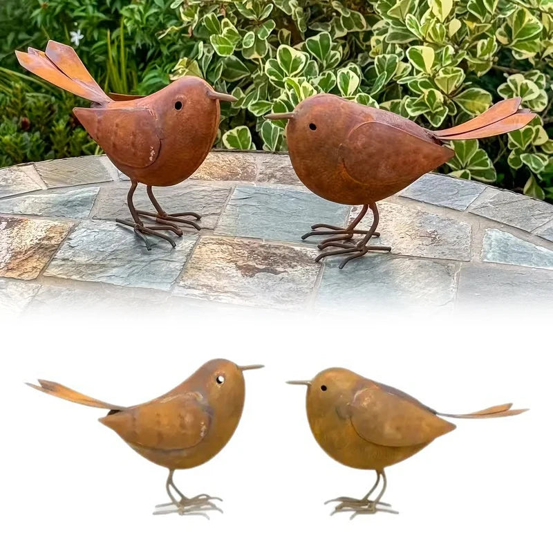 Two rustic metal bird sculptures in brown and gold colors standing on a stone surface.