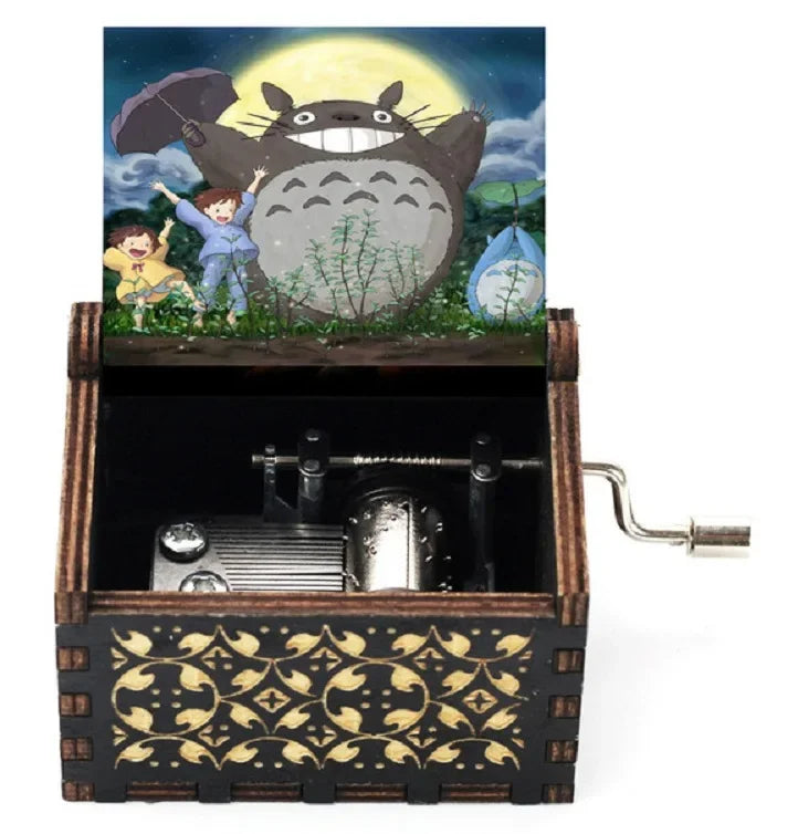 Hand-cranked wooden music box featuring a Totoro design with a large yellow sun in the background.
