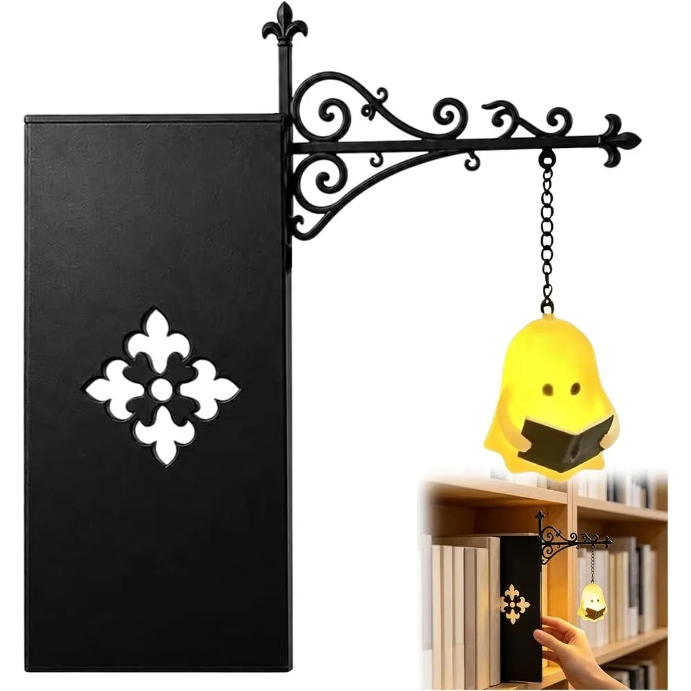 A black gothic bookshelf reading lamp with an ornate wrought iron arm and a warm amber glowing light.