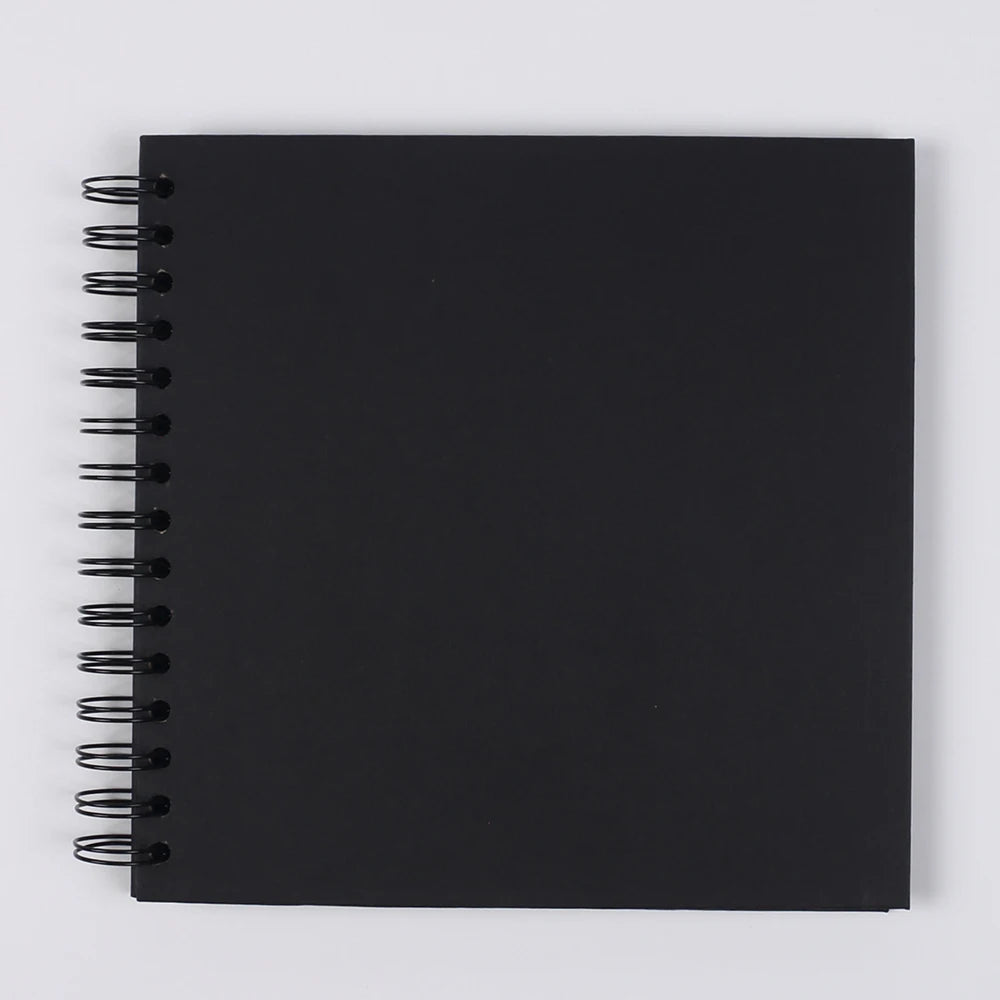 A black spiral-bound notebook or scrapbook for DIY memory keeping.
