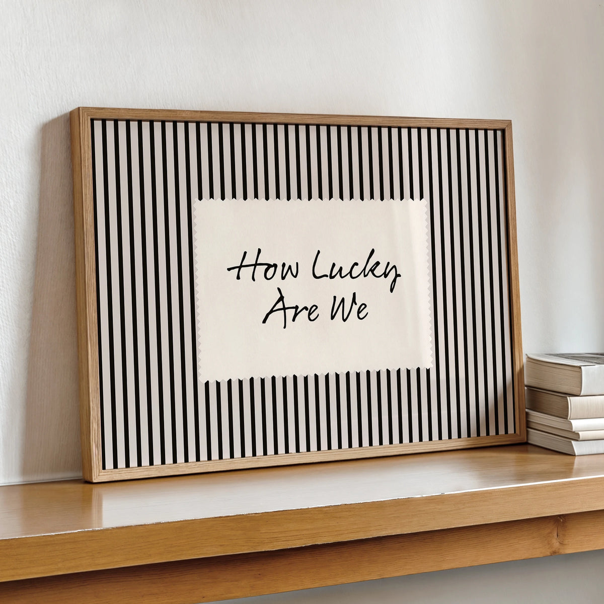 Framed canvas wall art with black vertical stripes and the text How Lucky Are We