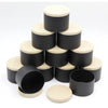 A set of black and natural wood metal candle tins with lids arranged in a pyramid formation.