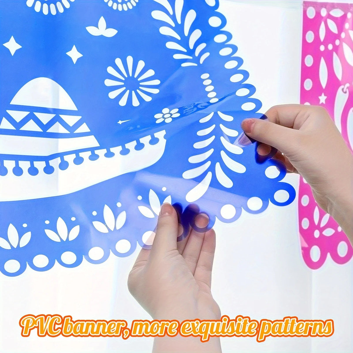 A hand is applying a blue PVC banner with white cutout patterns onto a pink background.