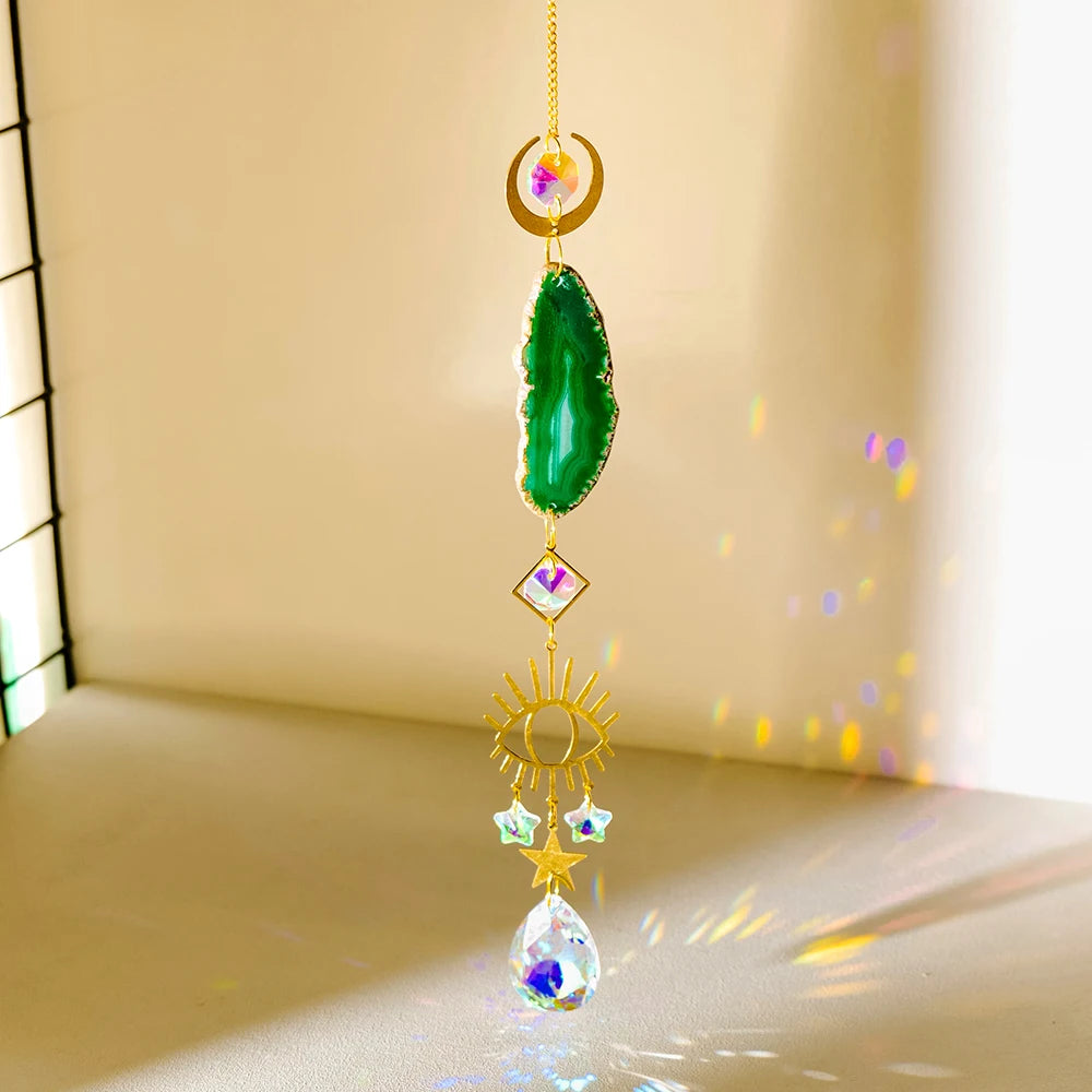 A hanging crystal decor featuring a green natural agate stone, gold accents, and a sun catcher design.