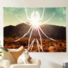 A white silhouette of a spider against a sunset background is displayed on a canvas print.