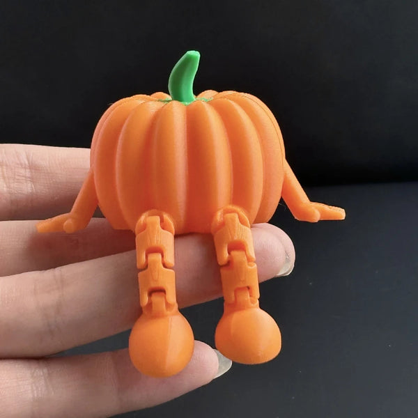 An orange 3D printed ghost figurine with green stem and articulated limbs being held in a hand.
