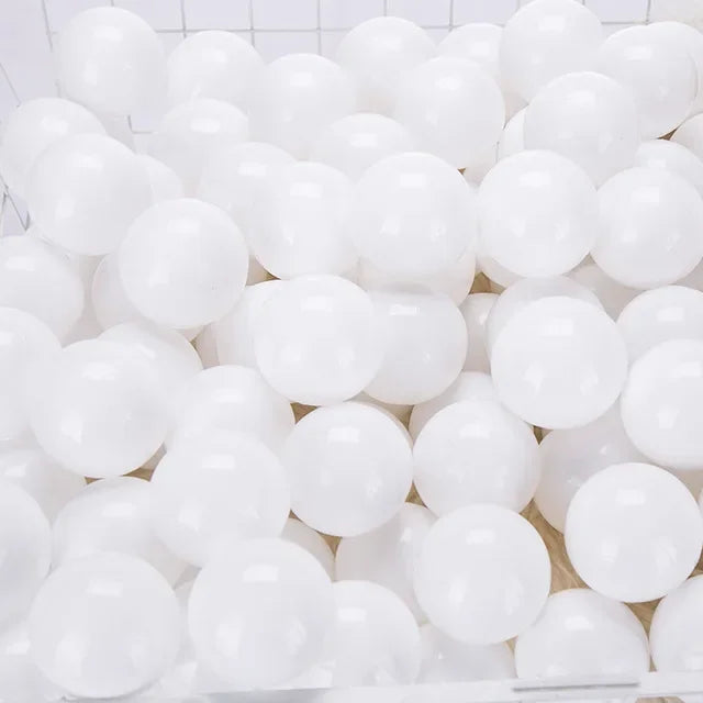 A large quantity of white, glossy, spherical balls for play areas and ball pits.