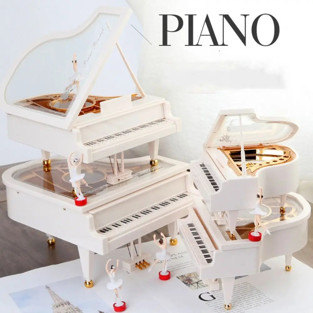 A white piano music box featuring a hand-crank mechanism and a ballerina figurine.