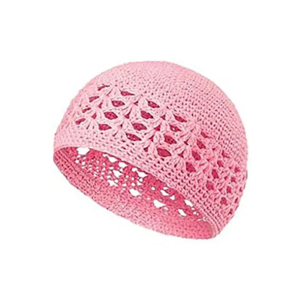 A pink handmade crochet beanie hat with an openwork lace pattern.