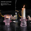Porta-velas de cristal transparente con base texturizada rosa y vela encendida.