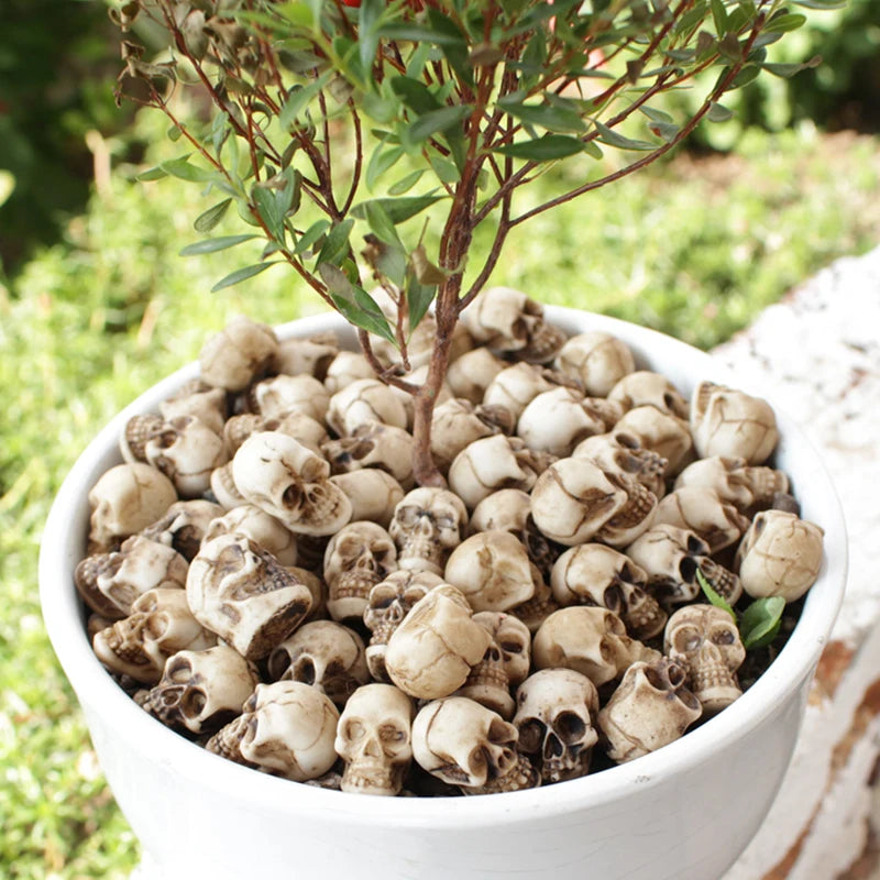 A white pot filled with twenty realistic resin mini skulls for garden decor, set of 20.