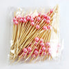 A bundle of pearl-tipped bamboo cocktail picks with a white pearl finish in clear packaging.