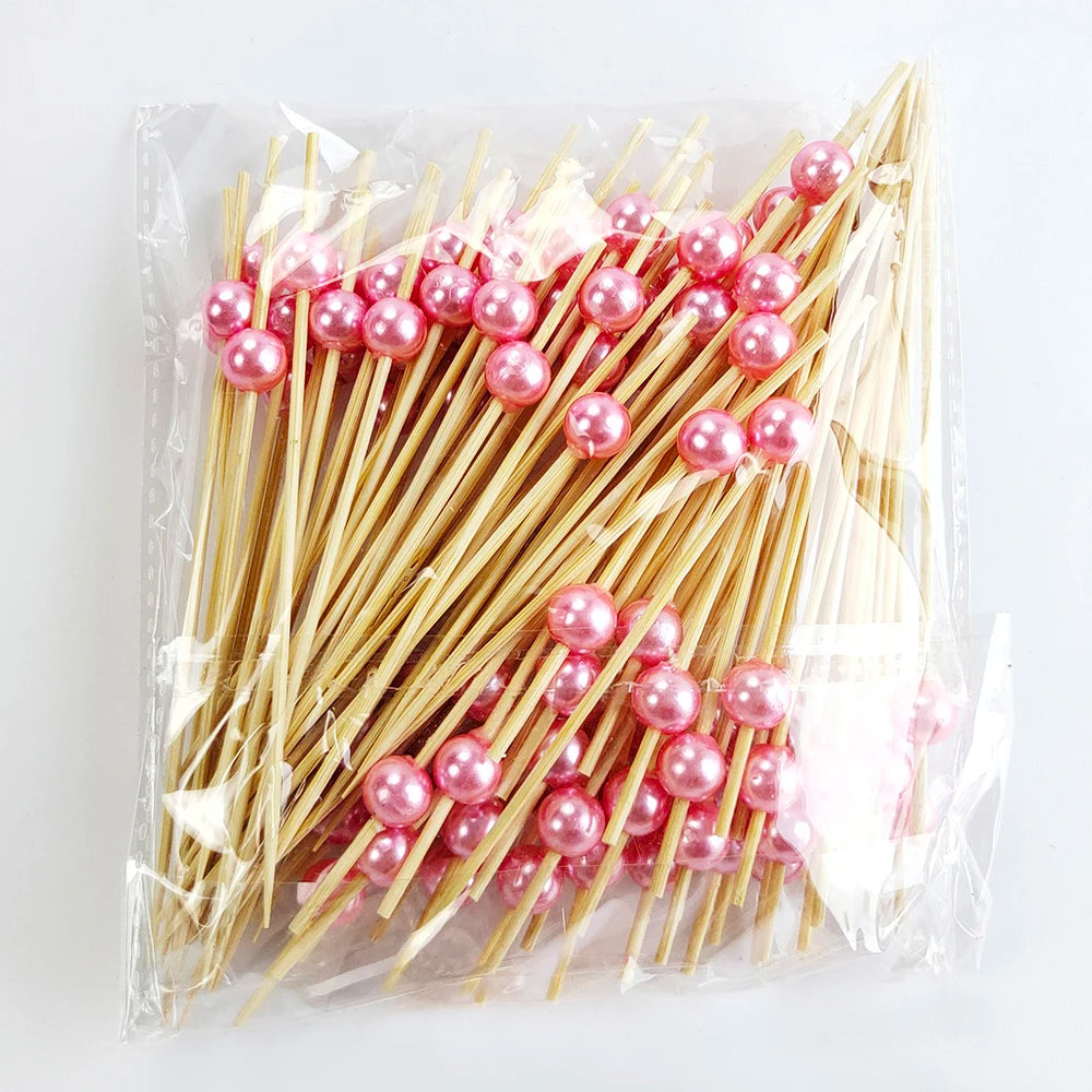 A bundle of pearl-tipped bamboo cocktail picks with a white pearl finish in clear packaging.