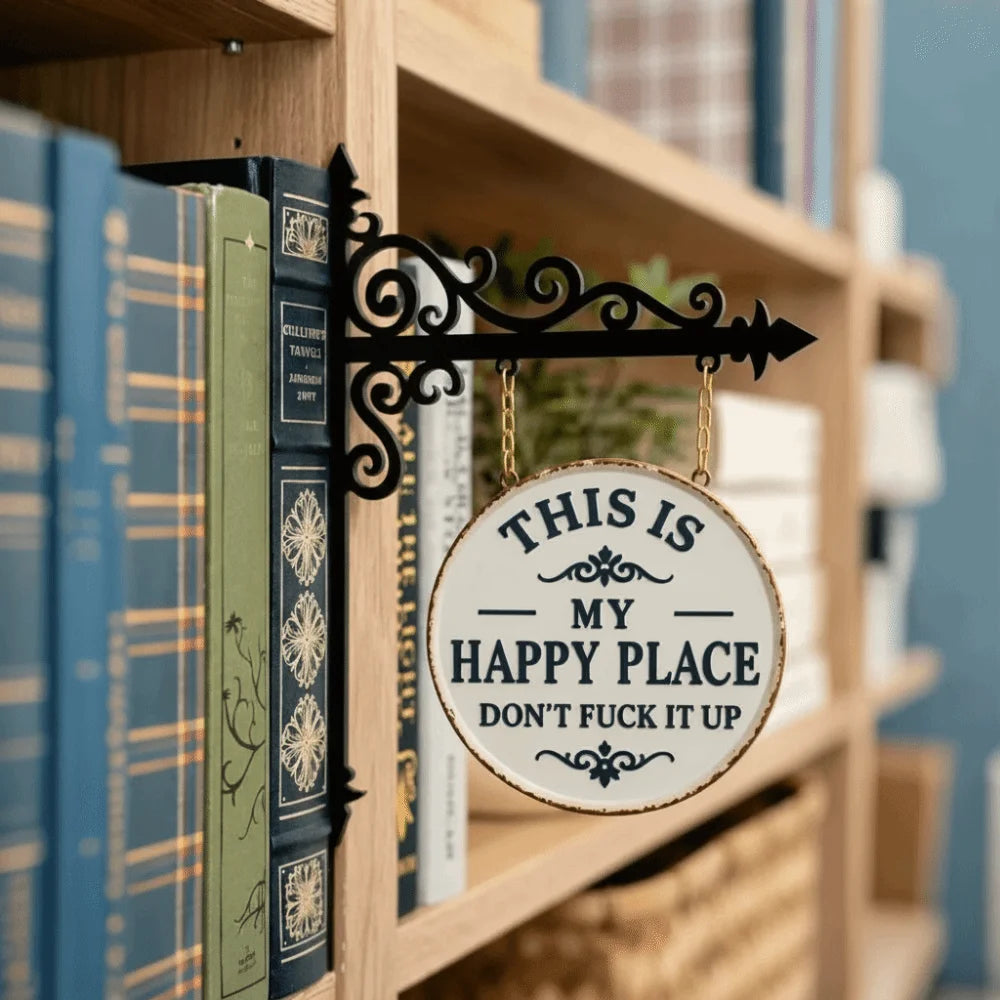 A black wrought iron sign with an arrow hangs on a wooden bookshelf next to vintage books.